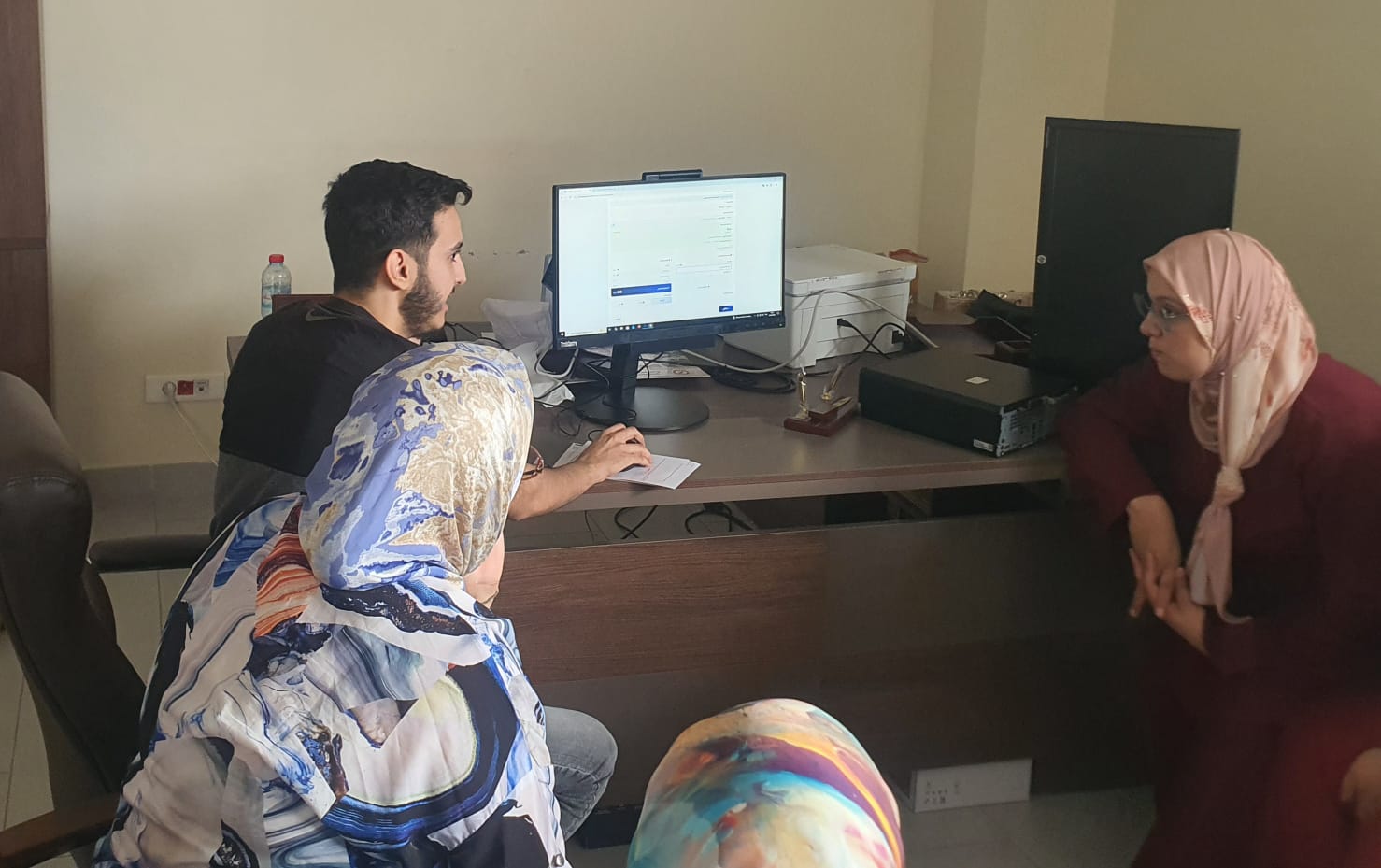 A Sanad Idari engineer walking a taxation-office team through GeoMiz on screen
